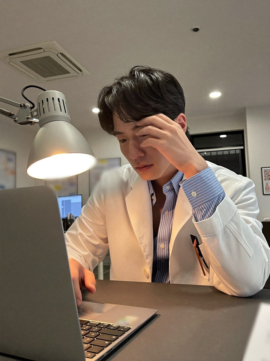 밤 진료실, 노트북 앞에서 원고를 쓰는 원장